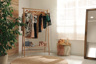 Rack with stylish women's clothes in room. Interior design