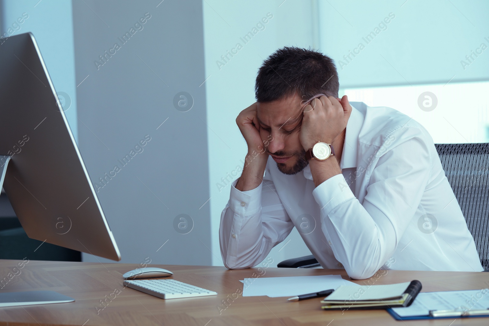 Photo of Sleepy man snoozing at workplace in office