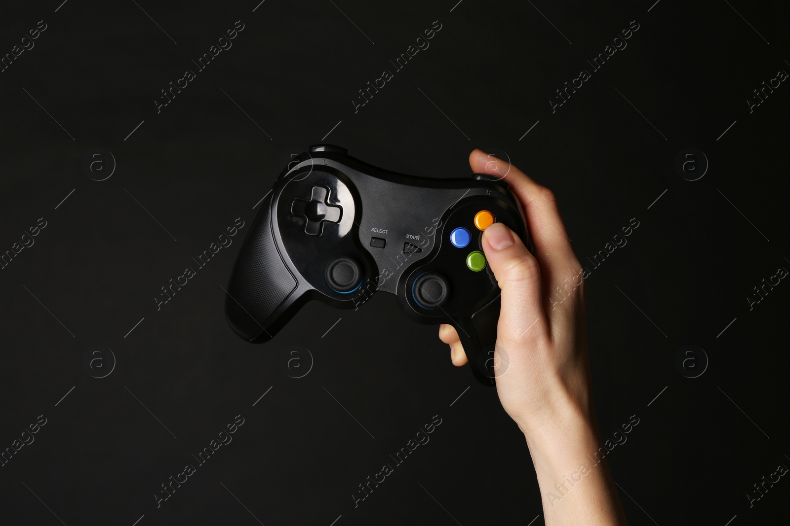 Photo of Woman with game controller on black background, closeup