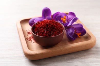 Photo of Dried saffron and crocus flowers on white wooden table