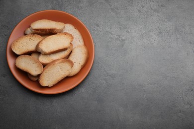 Photo of Plate of hard chuck crackers on grey table, top view. Space for text