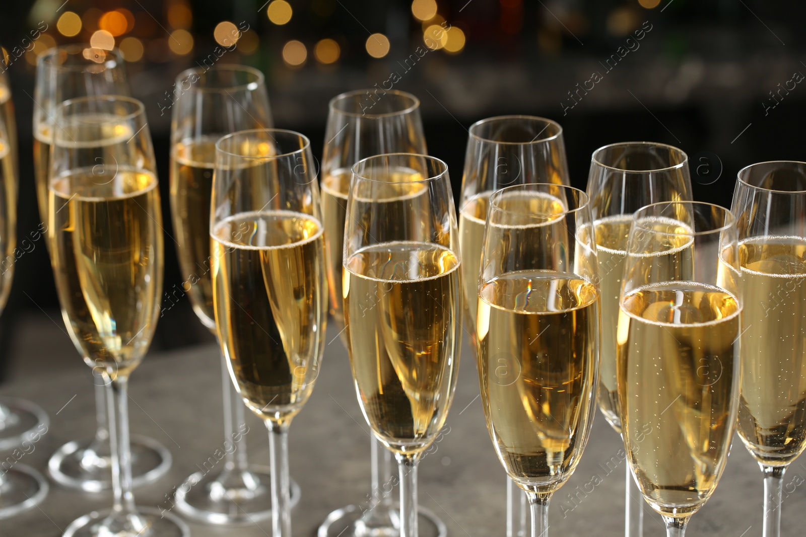 Photo of Glasses of champagne on table against blurred background