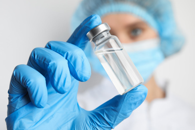 Doctor holding vial with medication, closeup. Vaccination and immunization