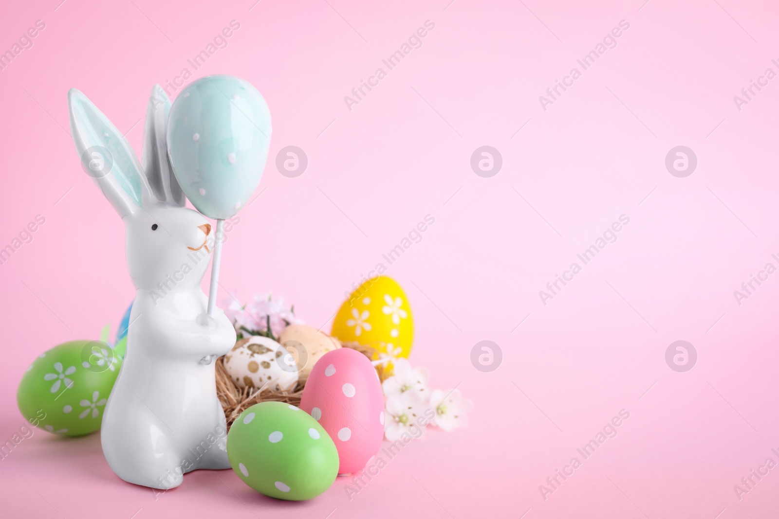 Photo of Composition with Easter bunny figure on pink background. Space for text