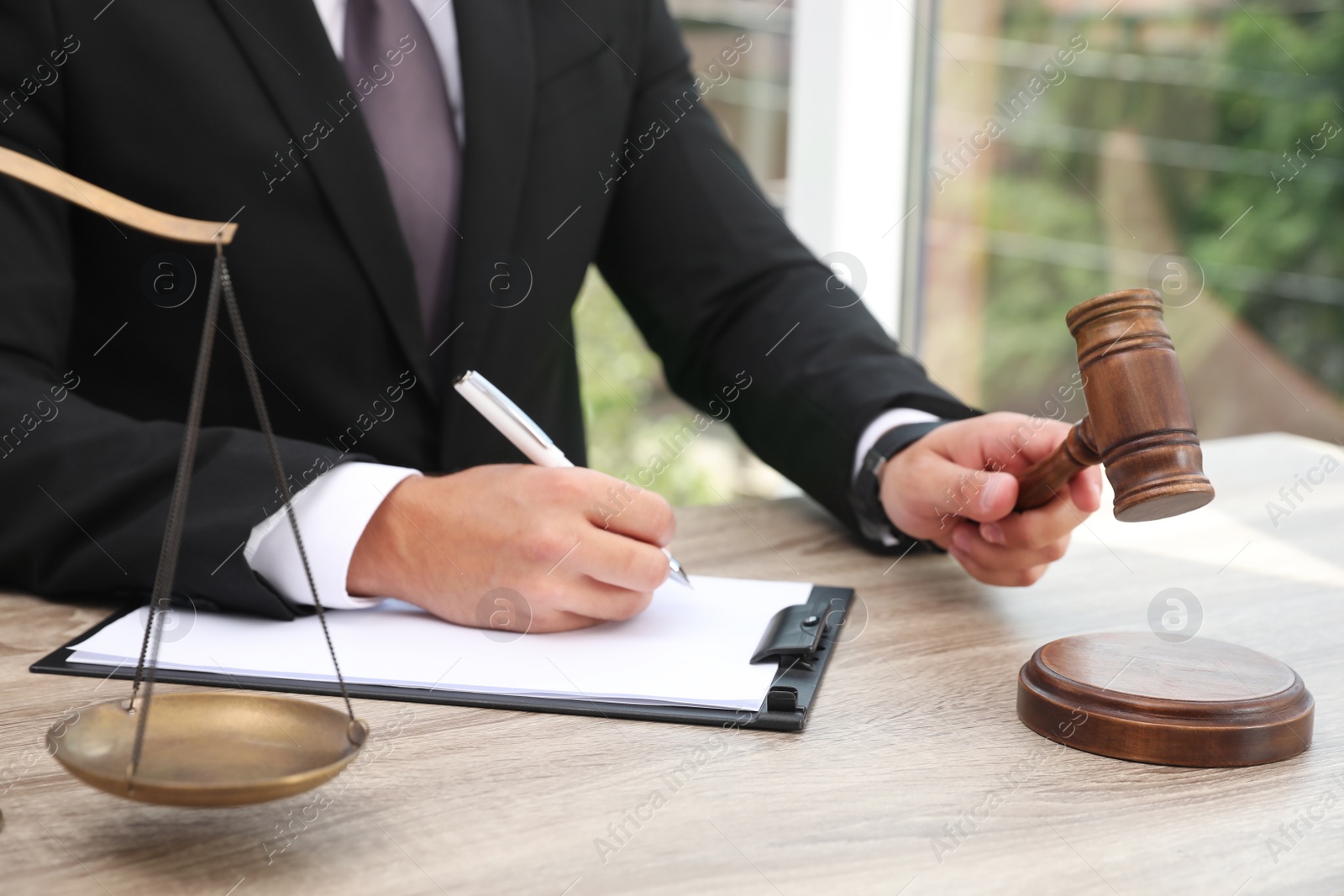 Photo of Judge working at wooden table indoors, closeup. Criminal law