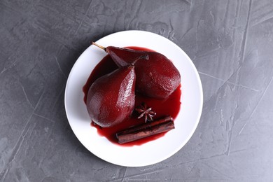 Tasty red wine poached pears and spices on grey table, top view