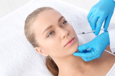 Photo of Young woman getting facial injection in clinic. Cosmetic surgery concept