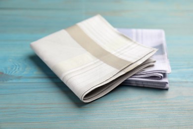Photo of Stylish handkerchiefs on light blue wooden table