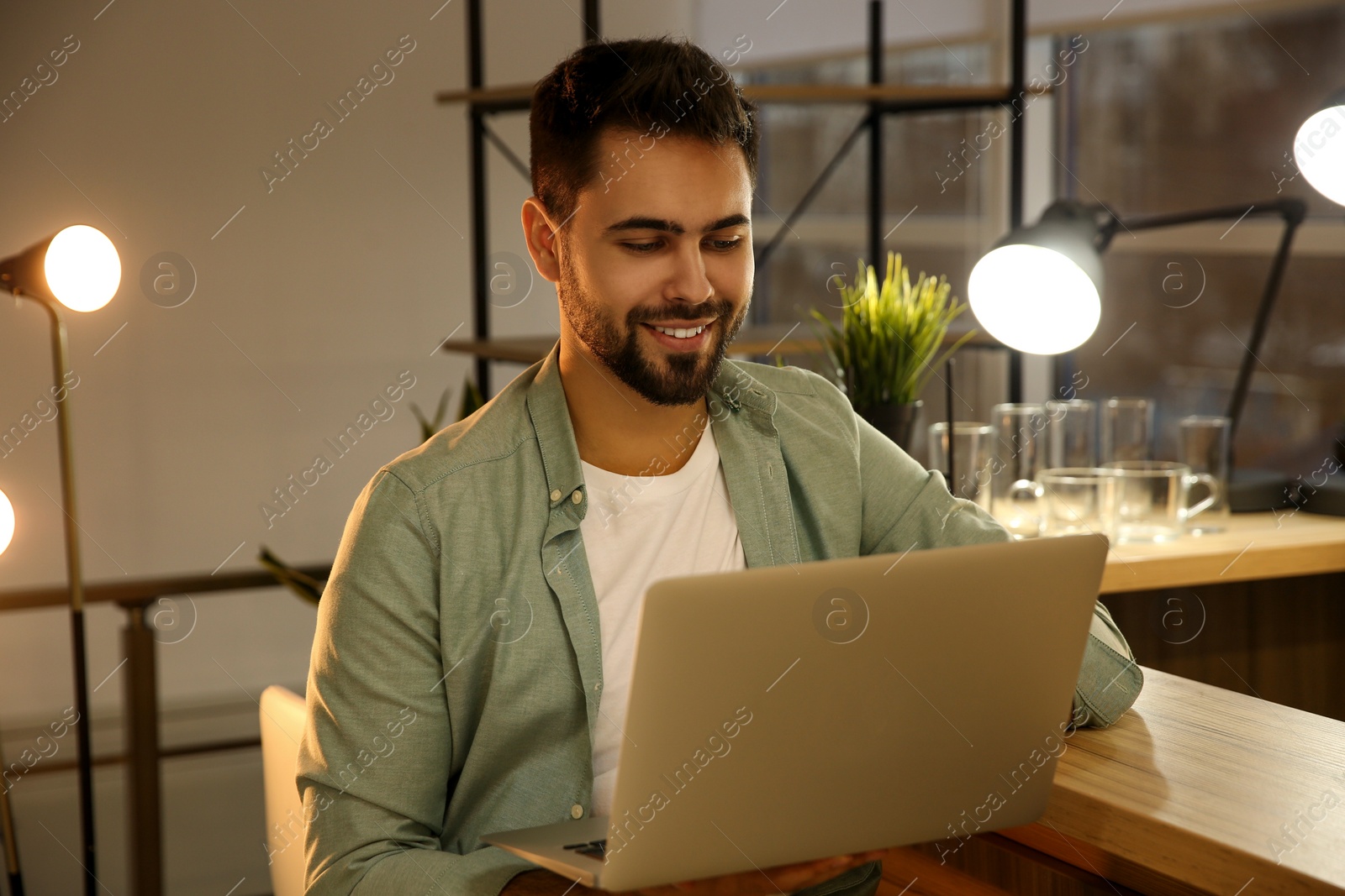 Photo of Man working with laptop at table in cafe