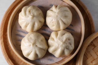 Photo of Delicious bao buns (baozi) on light table, top view