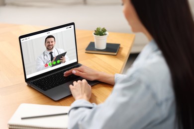 Online medical consultation. Woman having video chat with doctor via laptop at table indoors, closeup