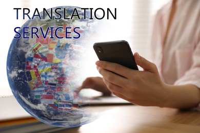Image of Translation services. Illustration of Earth with different flags and woman using smartphone at wooden table indoors, closeup