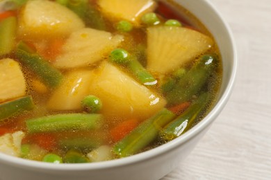 Bowl of delicious turnip soup on wooden table, closeup