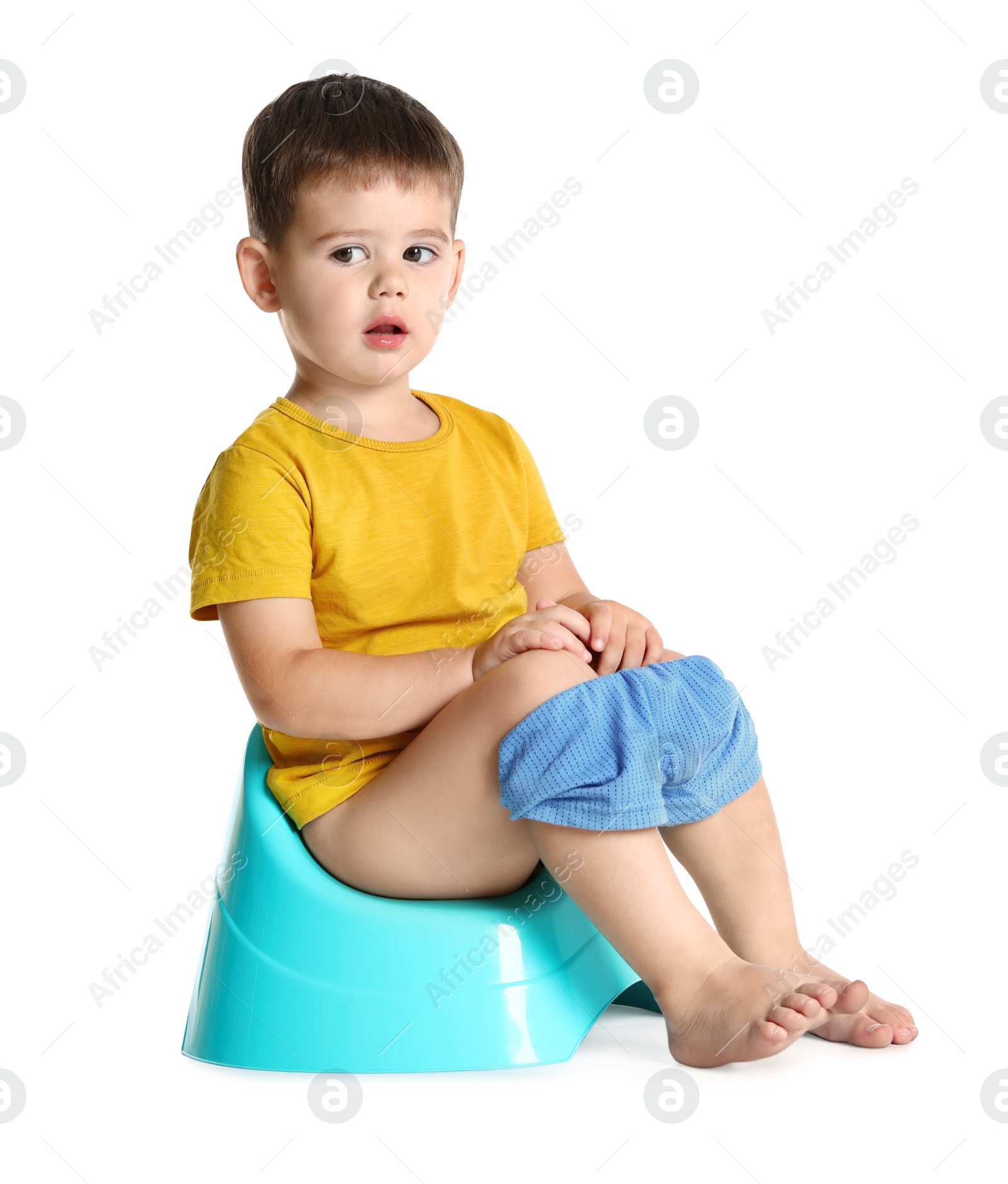 Photo of Portrait of little boy sitting on potty against white background