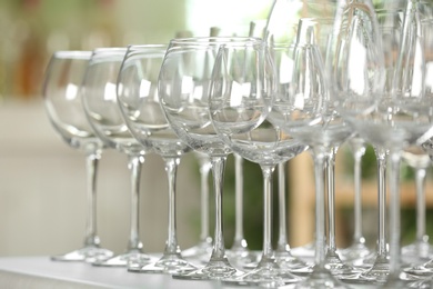 Photo of Empty glasses on table against blurred background