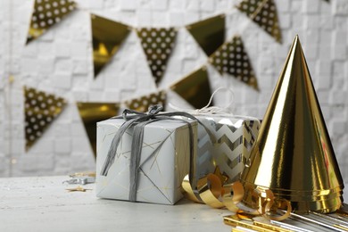 Photo of Gifts and party cones on table against blurred background