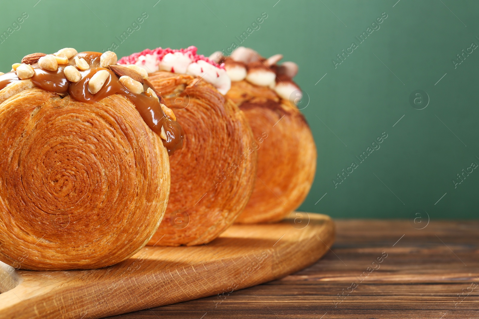Photo of Tasty puff pastry. Round croissants on wooden table, closeup. Space for text