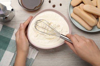 Woman making tiramisu cake at white wooden table, top view