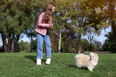 Little girl with her cute dog walking in park