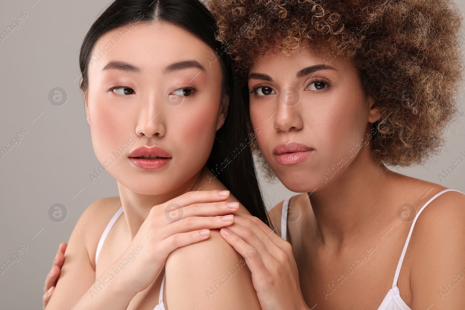 Photo of Beautiful young women with healthy skin on gray background