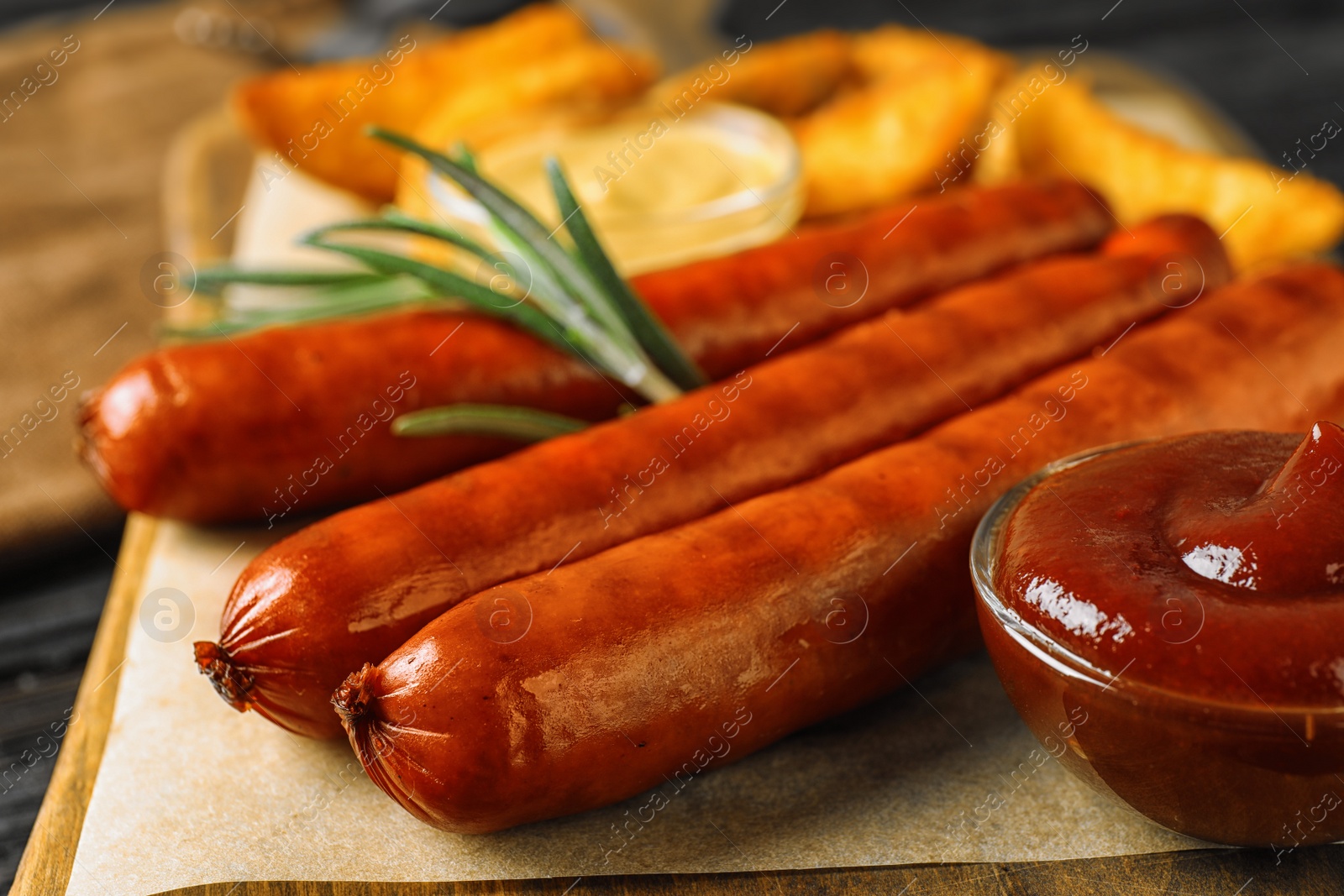 Photo of Delicious grilled sausages on wooden board, closeup. Barbecue food