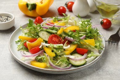 Photo of Tasty fresh vegetarian salad on grey table, closeup