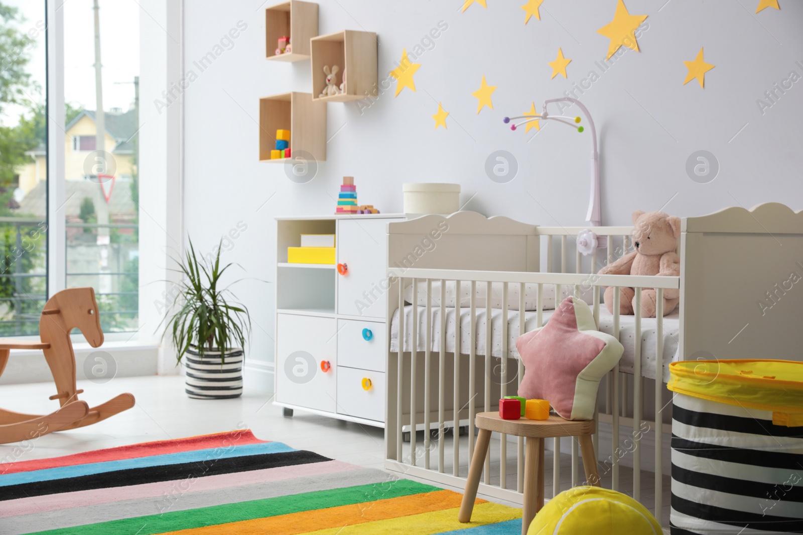 Photo of Stylish baby room interior with crib and toys