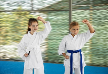 Photo of Children in kimono practicing karate on tatami outdoors