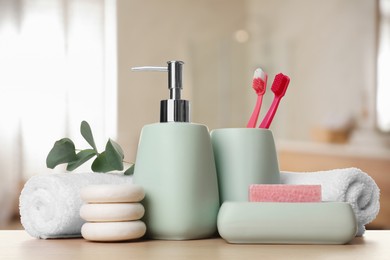 Image of Bath accessories. Different personal care products and eucalyptus leaves on wooden table in bathroom