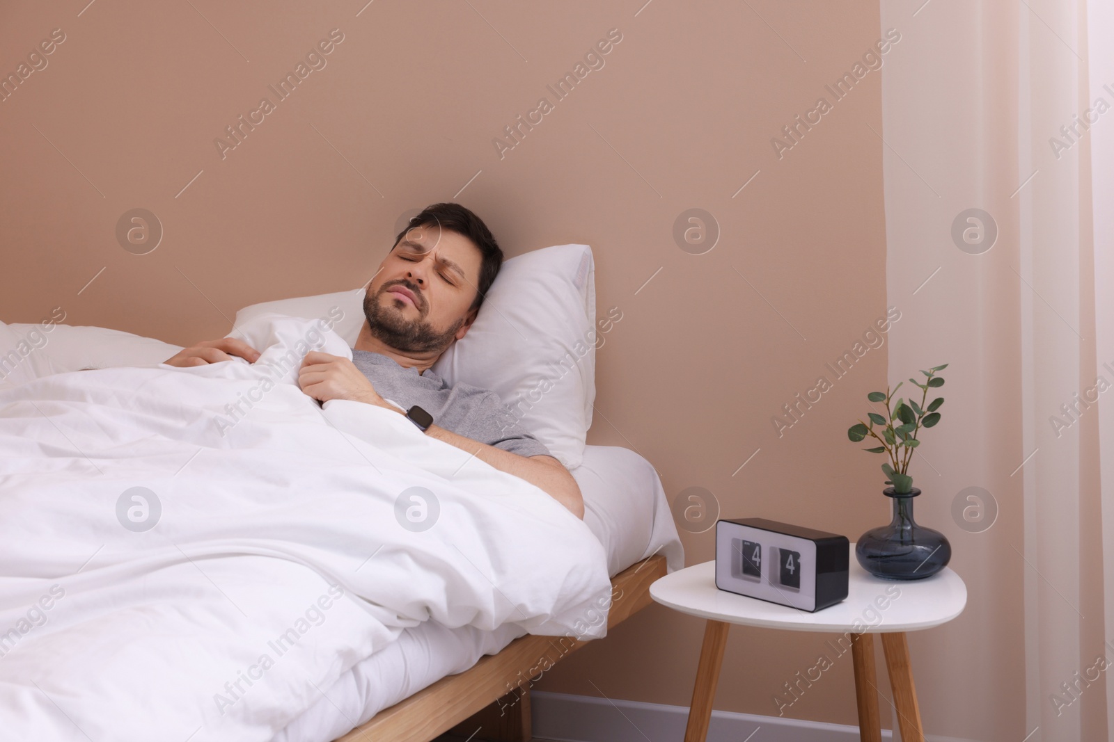 Photo of Sleepy man awaking in bed at home