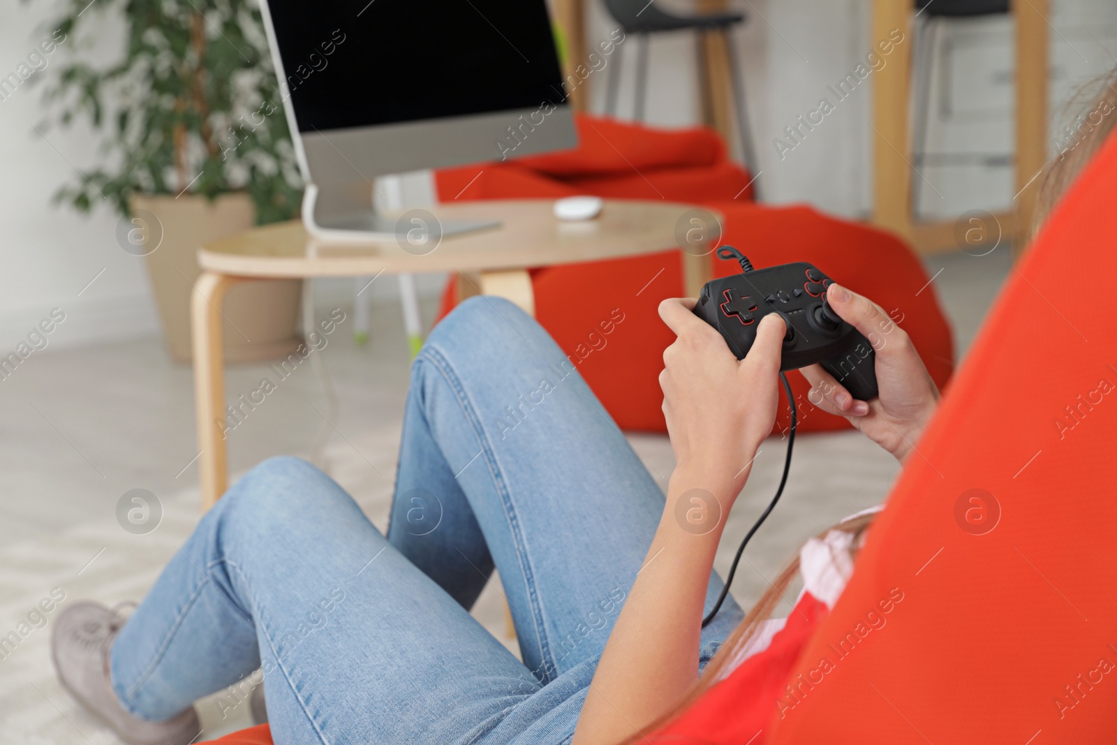 Photo of Young woman playing video games at home, closeup