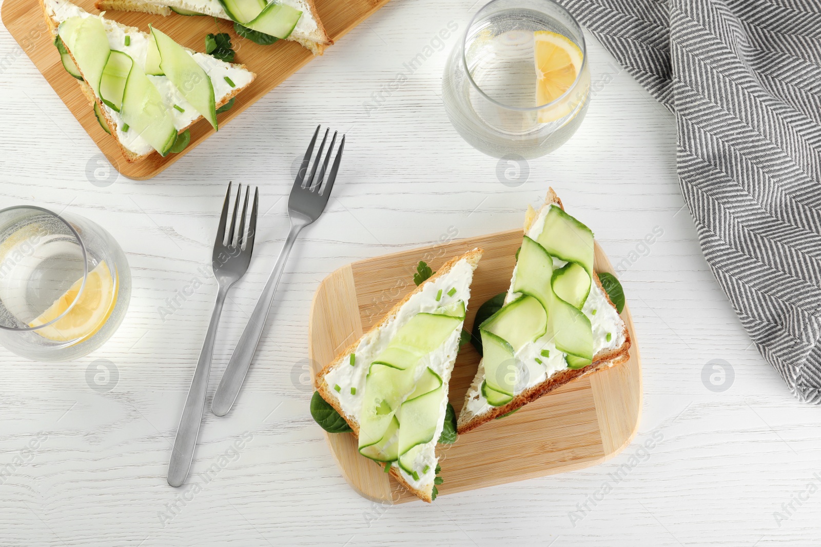 Photo of Flat lay composition with traditional English cucumber sandwiches on white wooden background