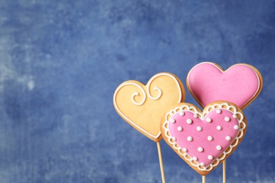 Decorated heart shaped cookie pops on color background. Space for text