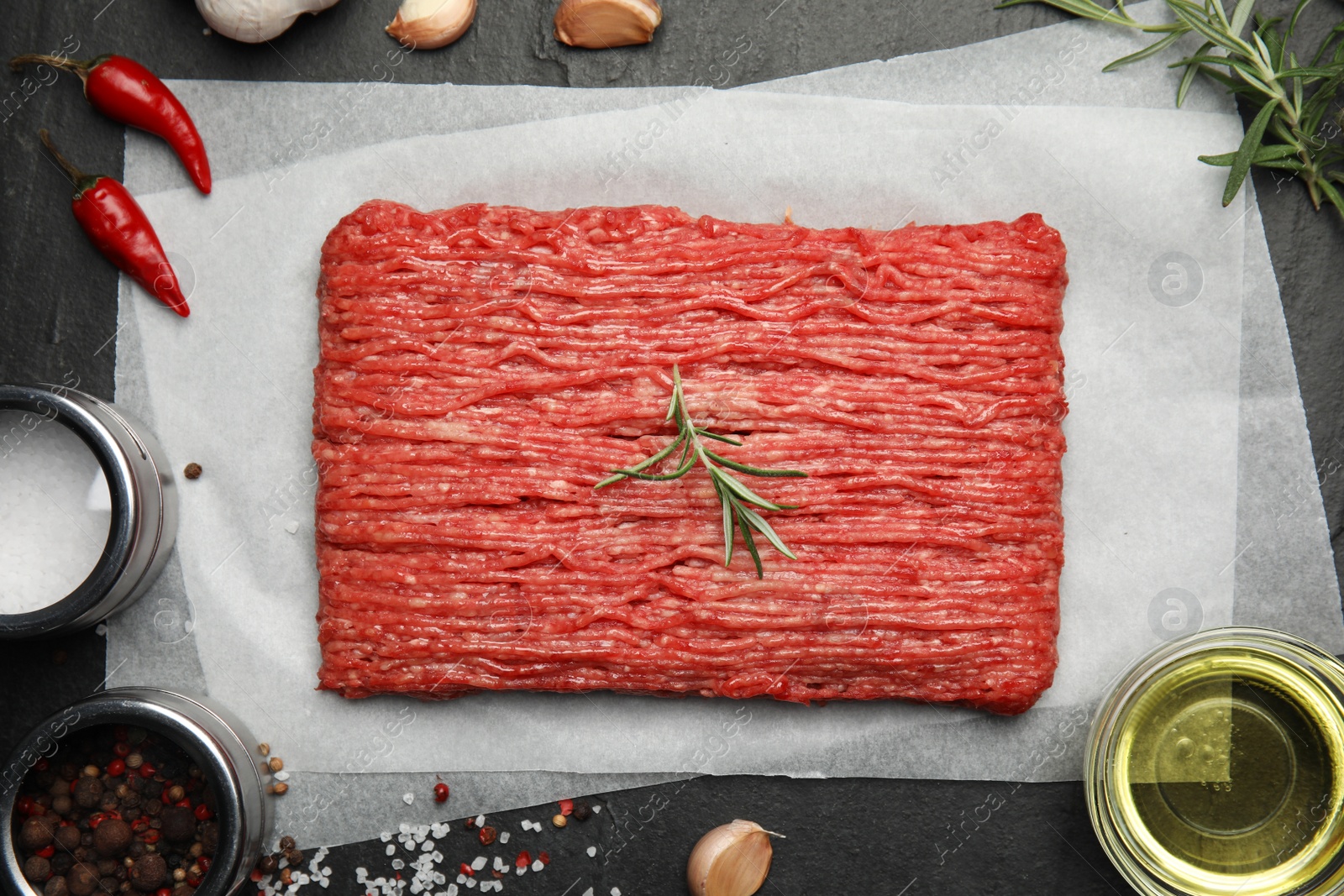 Photo of Raw fresh minced meat and other ingredients on black table, flat lay