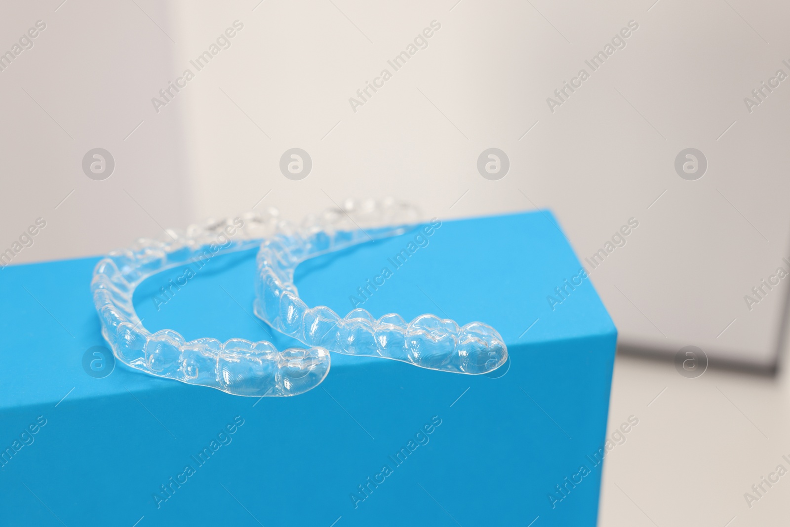 Photo of Transparent dental aligners on beige background, closeup. Space for text