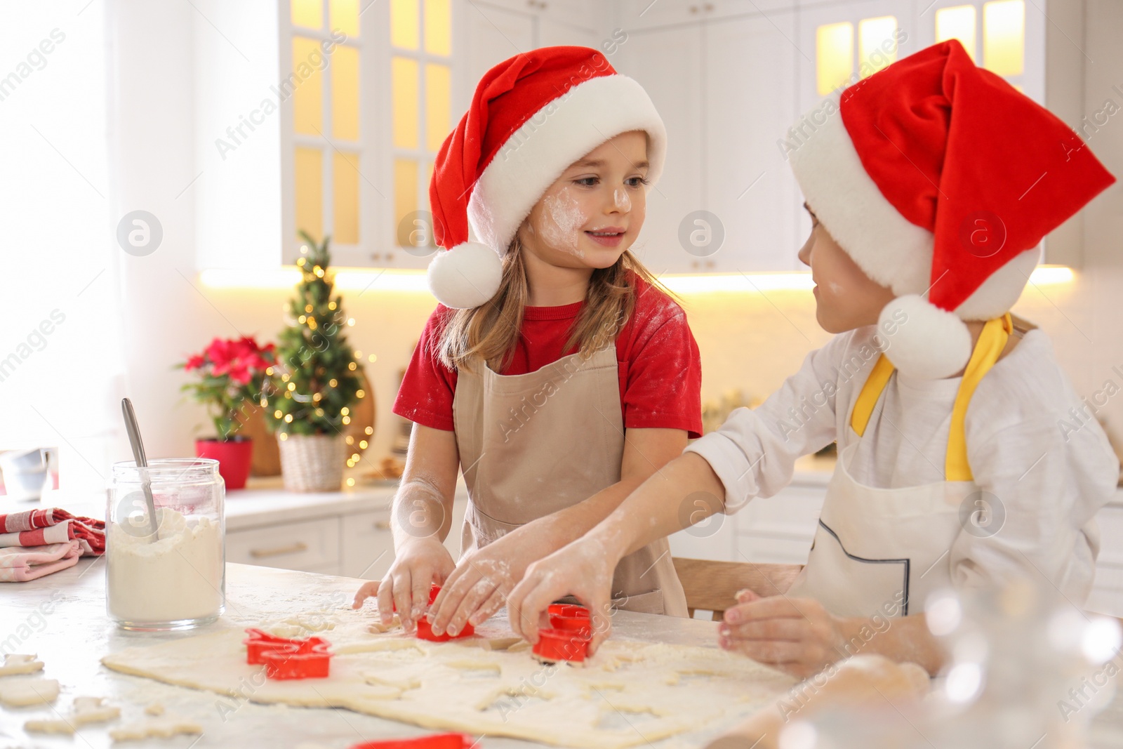 Photo of Cute little children making Christmas cookies in kitchen