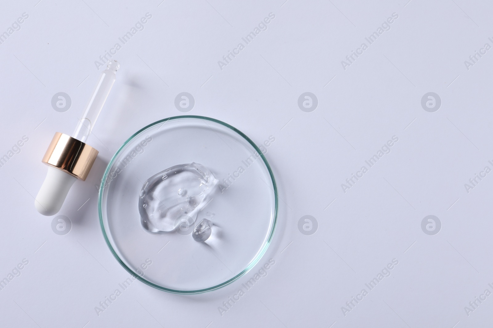 Photo of Petri dish with cosmetic serum and pipette on white background, top view. Space for text