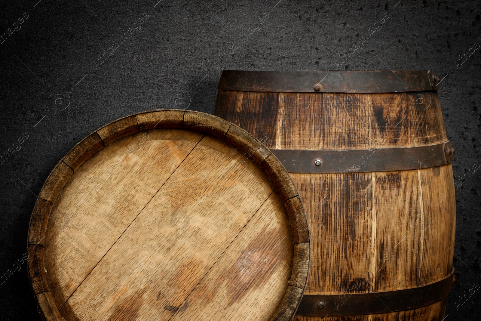 Image of Two wooden barrels near dark textured wall