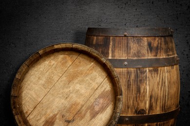 Image of Two wooden barrels near dark textured wall