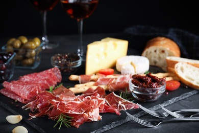 Photo of Tasty fresh prosciutto served on grey table