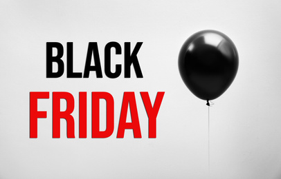 Text BLACK FRIDAY and big balloon on light background