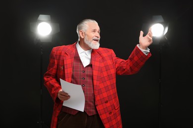 Senior actor with script performing on stage