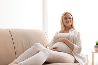 Photo of Beautiful pregnant woman resting on sofa at home