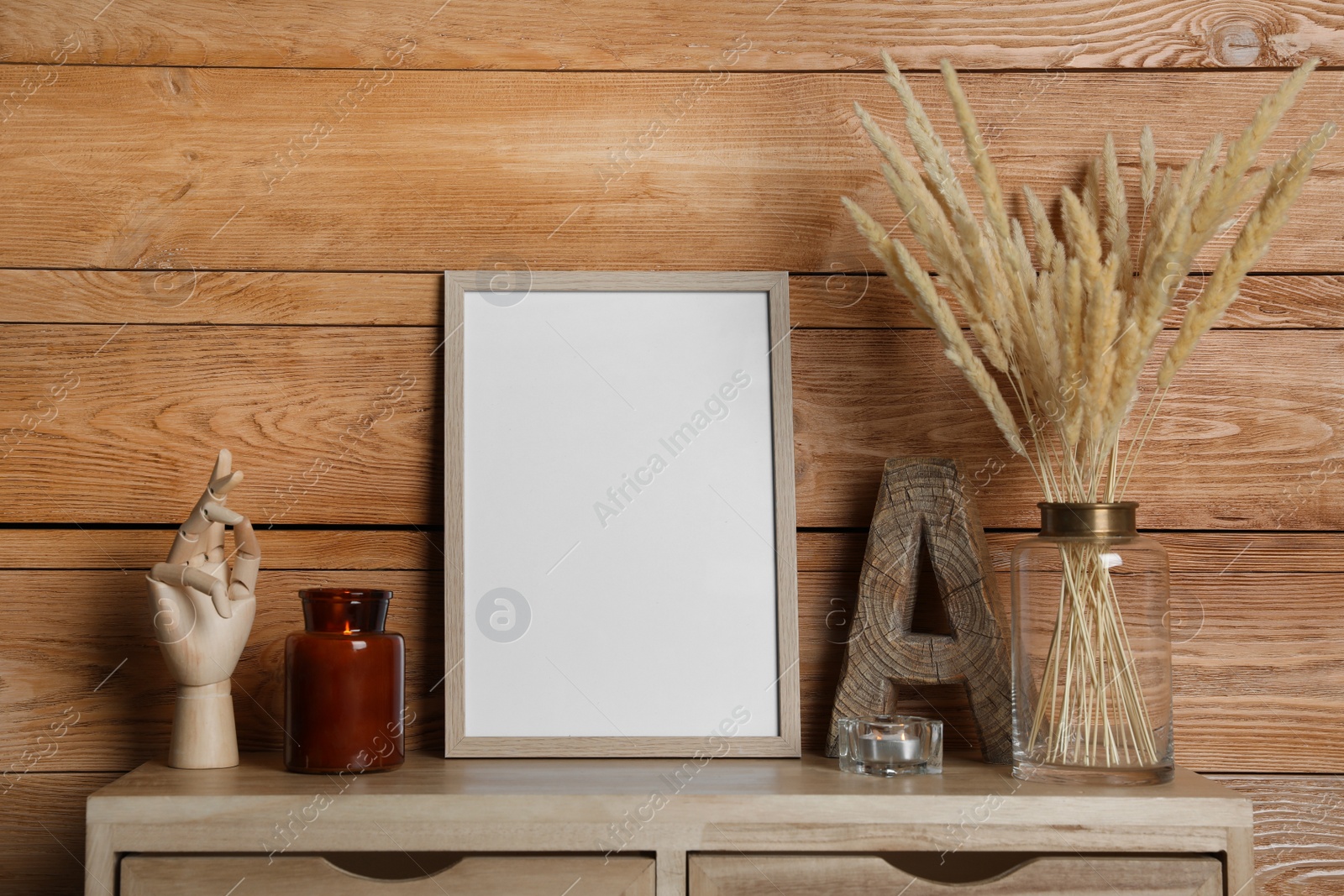 Photo of Empty frame with other decor on table near wooden wall. Mockup for design