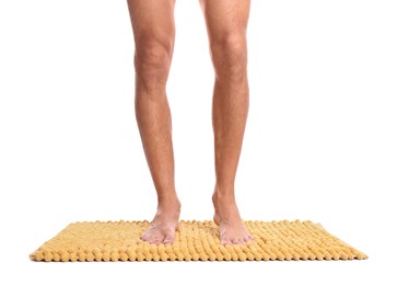 Man standing on soft yellow bath mat against white background, closeup