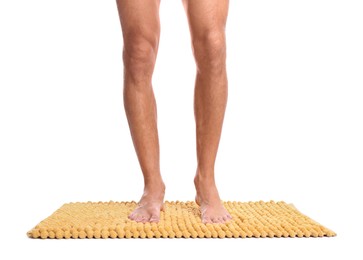 Photo of Man standing on soft yellow bath mat against white background, closeup