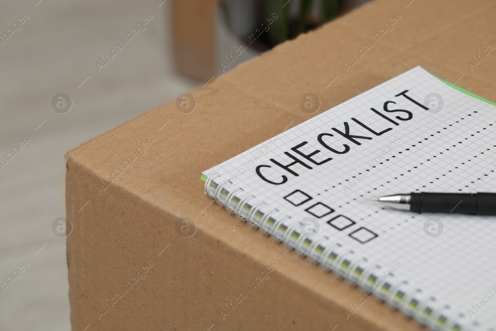 Photo of Notebook with inscription Checklist and pen on box, closeup