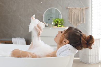 Beautiful woman enjoying bubble bath at home