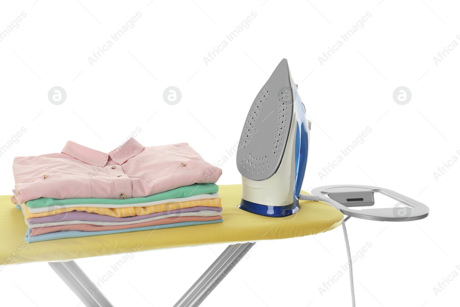 Photo of Board with modern iron and clean laundry on white background