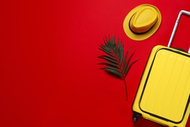 Photo of Stylish suitcase, hat and exotic leaf on color background, flat lay. Space for text